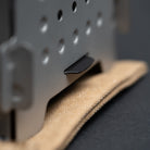 Close-up image of the grey stainless steel Stöker Stove by Überleben. The twig stove rests on the waxed canvas pouch.