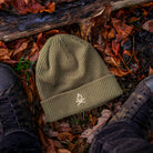 Überleben Icon Beanie in some fall leaves.