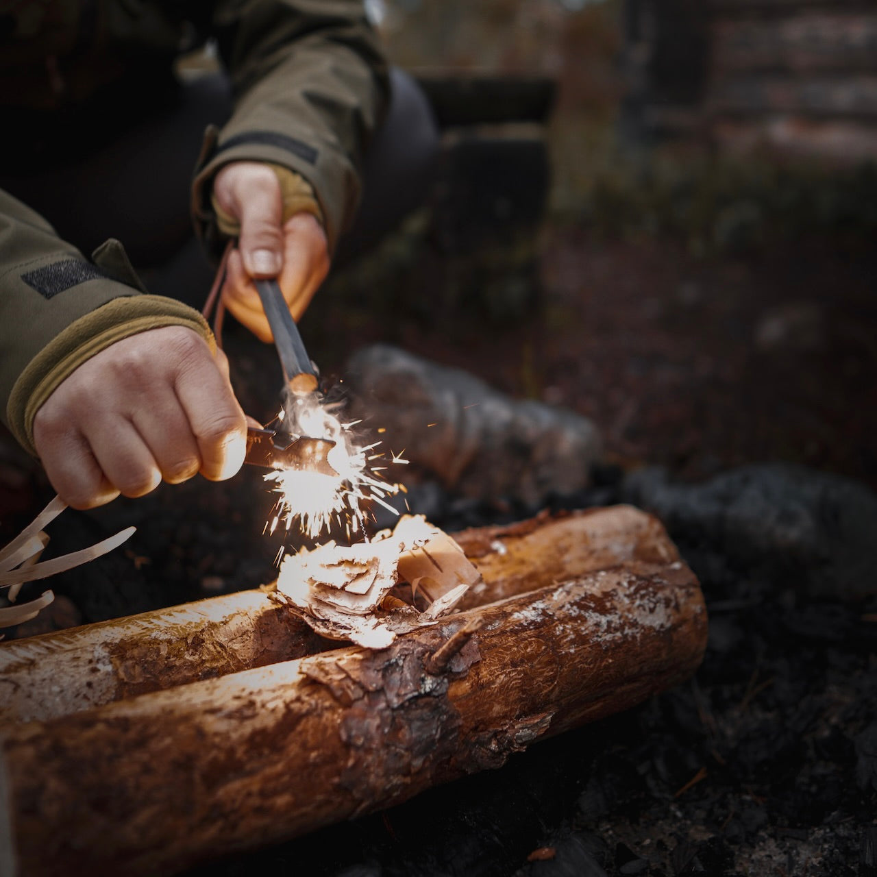 Überleben Hexå ferrocerium rod throwing sparks onto some birch bark.