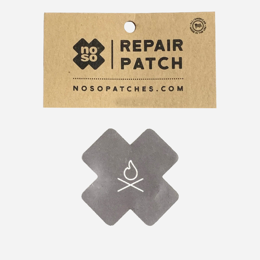 The Überleben x NOSO Fire Repair Patch, featuring a simple fire icon at its center, is displayed. This durable, waterproof patch utilizes a Peel & Stick method for effortless application.