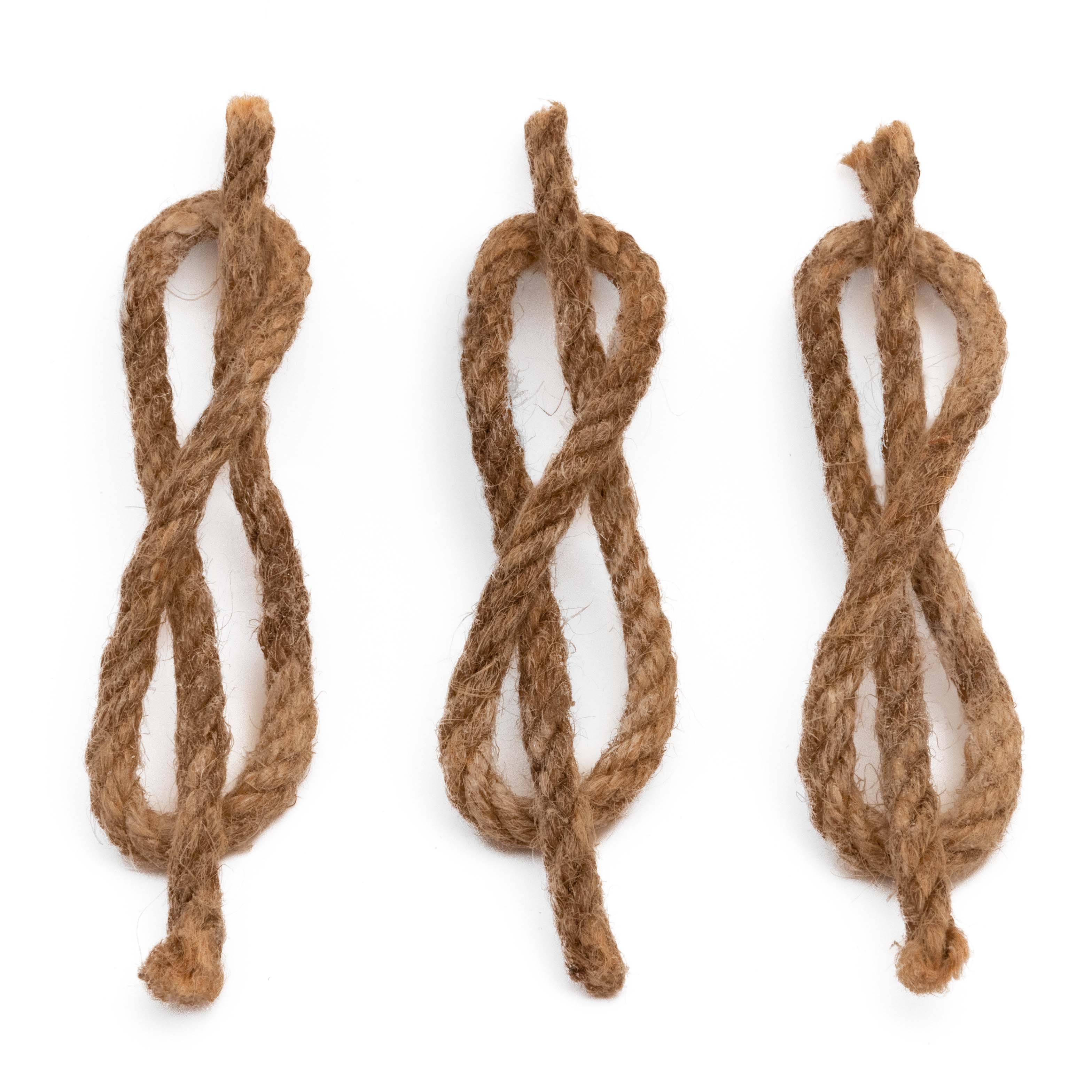 Three Tindår Wicks, paraffin infused hemp ropes for easy fire starting, rest on a white surface.